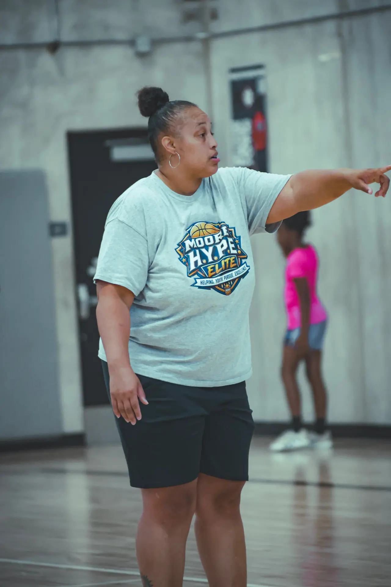 Coach Tamara Moore in a Moore H.Y.P.E. Elite tee calling out a play