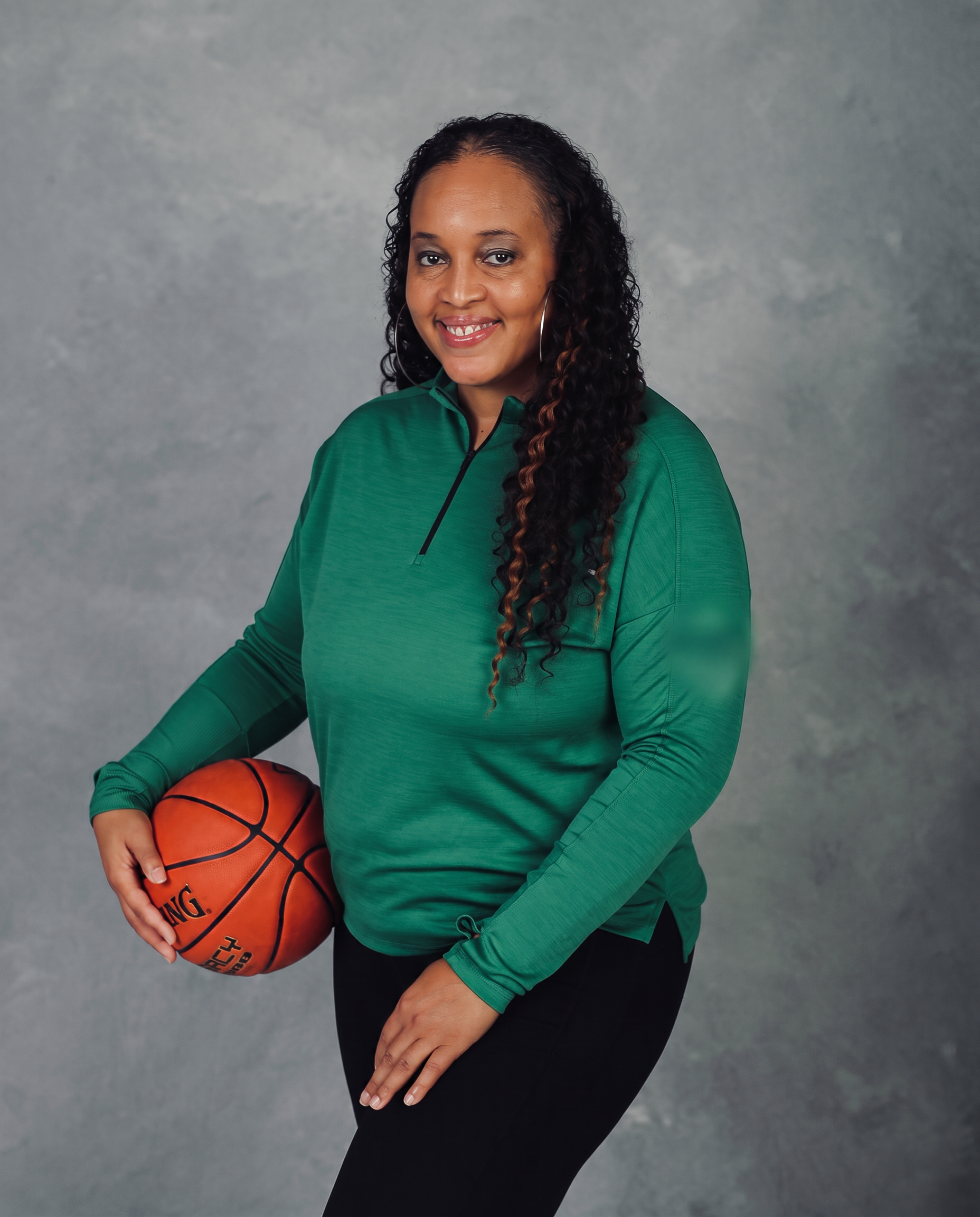 Tamara Moore holding a basketball in the gym
